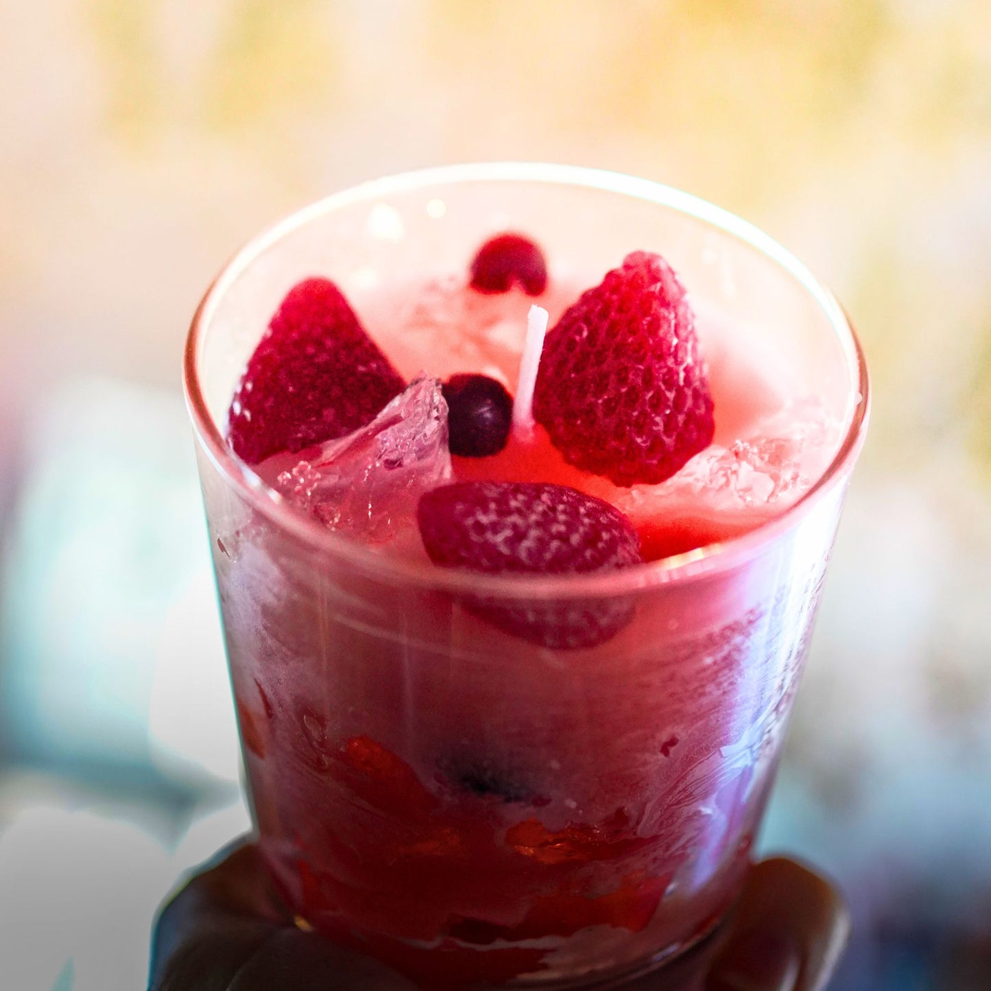 Kerze mit roten Wachsbeeren als sommerliche Tischdeko