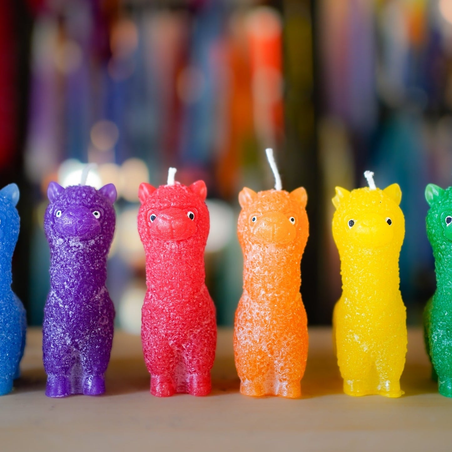 Sechs handgemachte Alpaka-Kerzen im Regenbogen-Set in Blau, Violett, Rot, Orange, Gelb und Grün