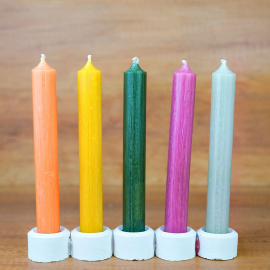 Stabkerzen-Set Gute Laune: Orange, Gelb, Dunkelgrün, Pink und Salbei nebeneinander in weißen Kerzenhaltern