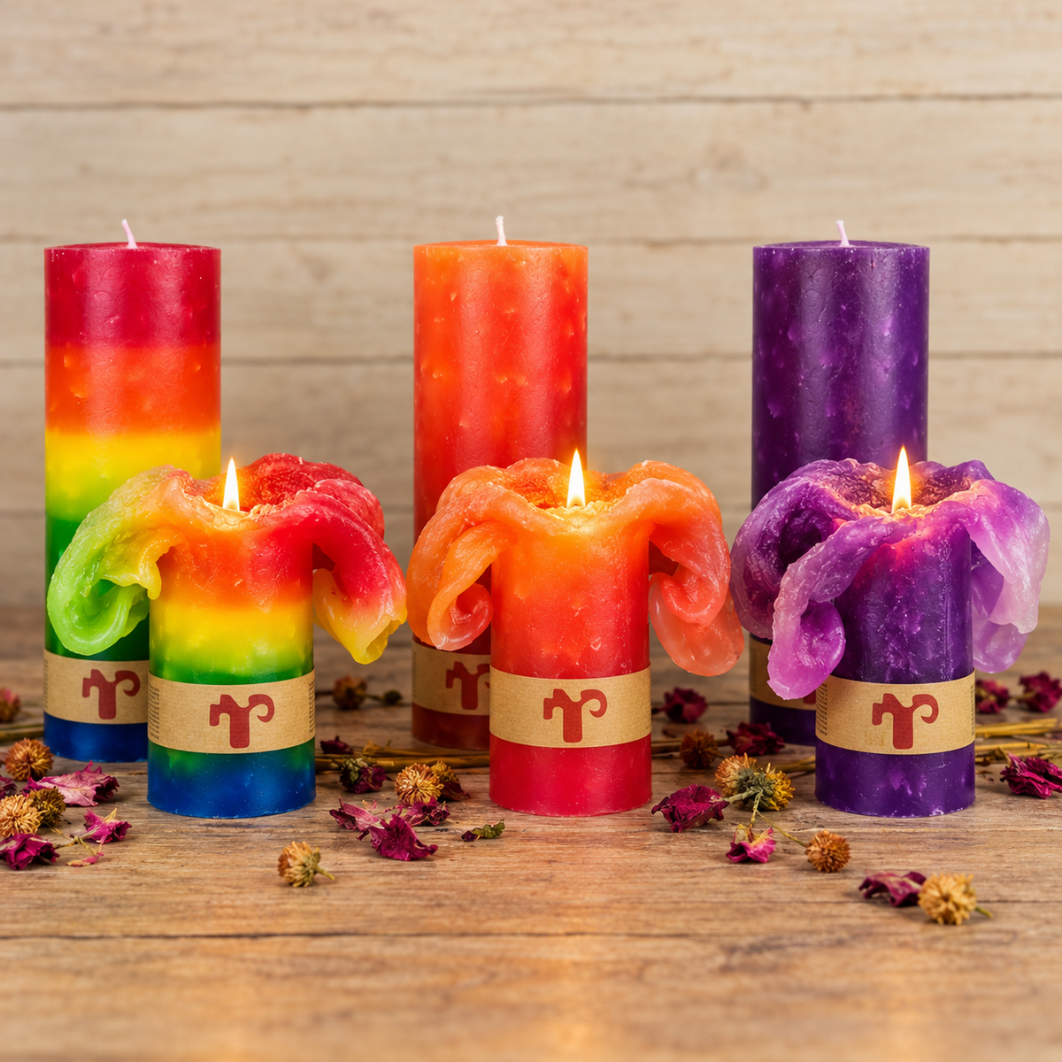Lotus Blütenkerzen in Orange, Lila und Regenbogen auf rustikalem Holztisch, brennend mit Blüteneffekt