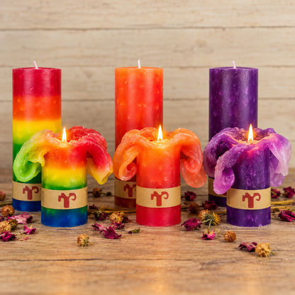 Lotus Blütenkerzen in Orange, Lila und Regenbogen auf rustikalem Holztisch, brennend mit Blüteneffekt
