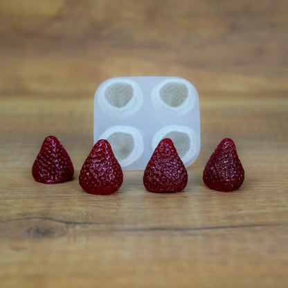 Silikonform mit 4 Beeren-Mulden und dunkelrot gegossenen Wachserdbeeren aus dem Set