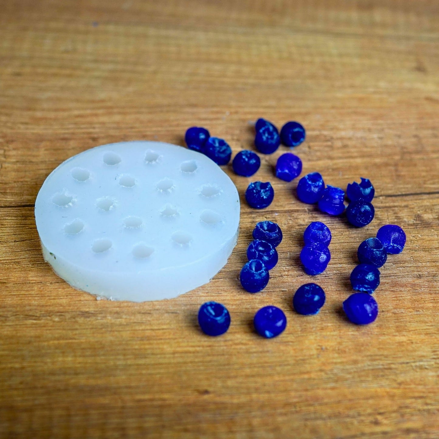 Runde Silikonform für Mini-Beeren mit blau gegossenen Wachsbeeren aus dem Früchte-Set