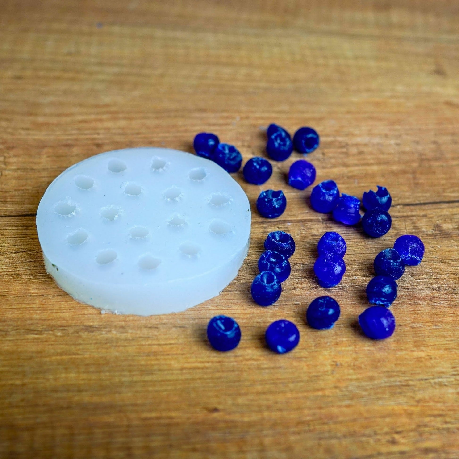 Runde Silikonform für Mini-Beeren mit blau gegossenen Wachsbeeren aus dem Früchte-Set