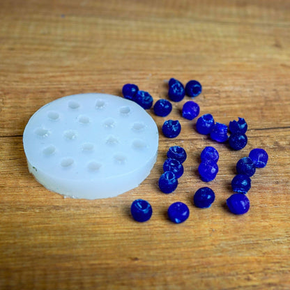 Runde Silikonform für Mini-Beeren mit blau gegossenen Wachsbeeren aus dem Früchte-Set