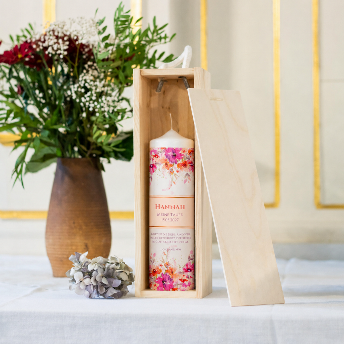 Taufkerze Flower Power in der Holz-Kerzenbox neben Blumen als Geschenkidee zur Taufe