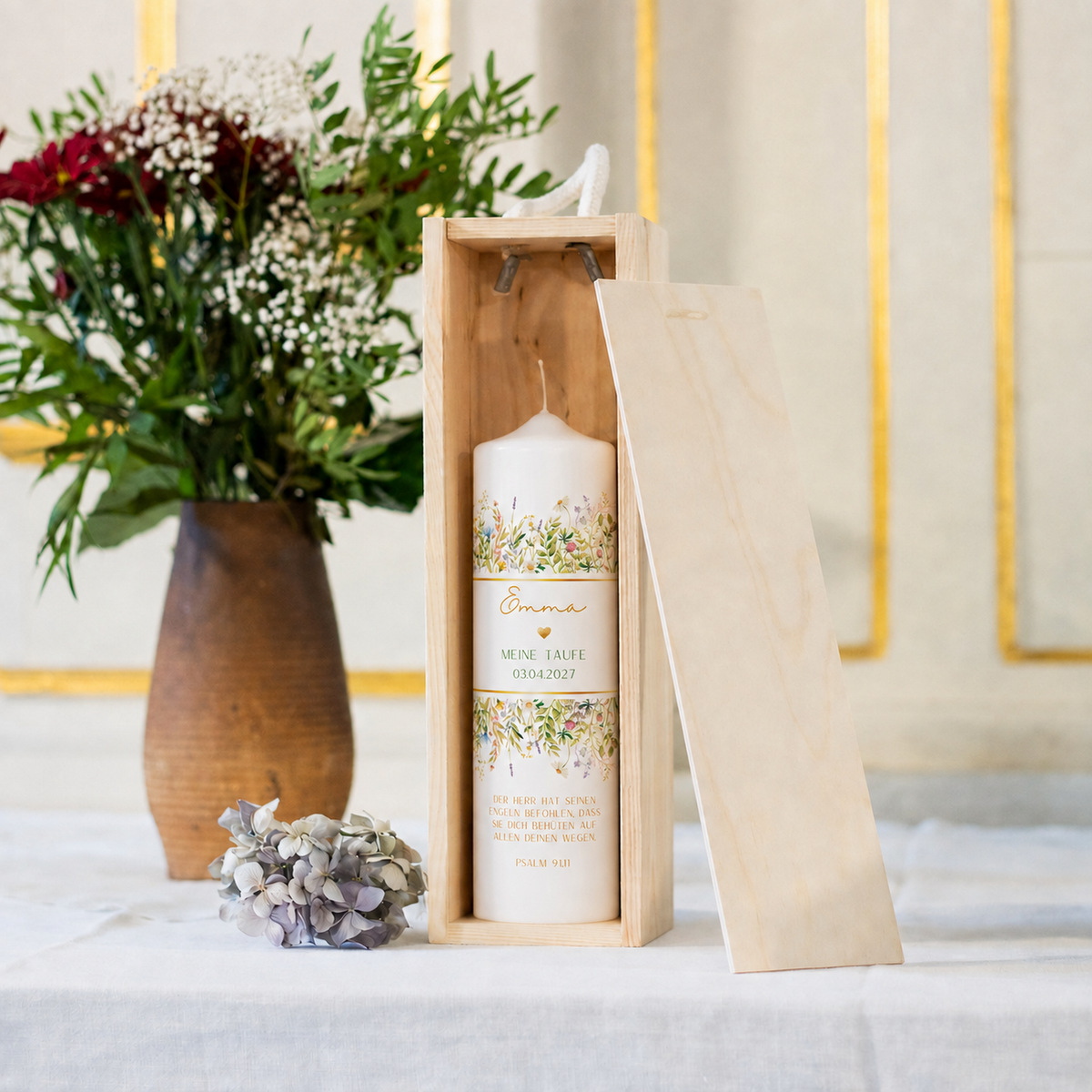 Taufkerze Wiesenblumen Gold in der Holz-Kerzenbox neben Blumen als Geschenkidee