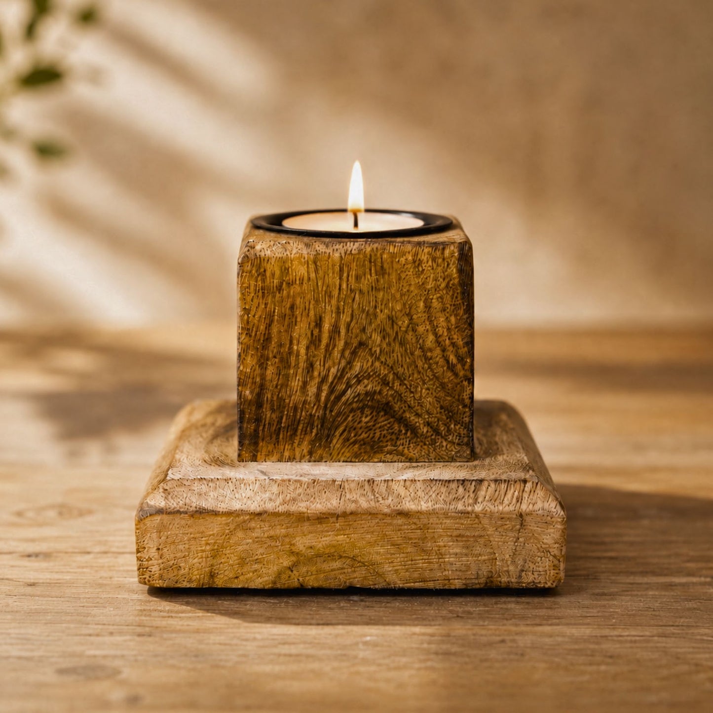 Teelichthalter aus Mangoholz mit brennendem Teelicht auf Holztisch