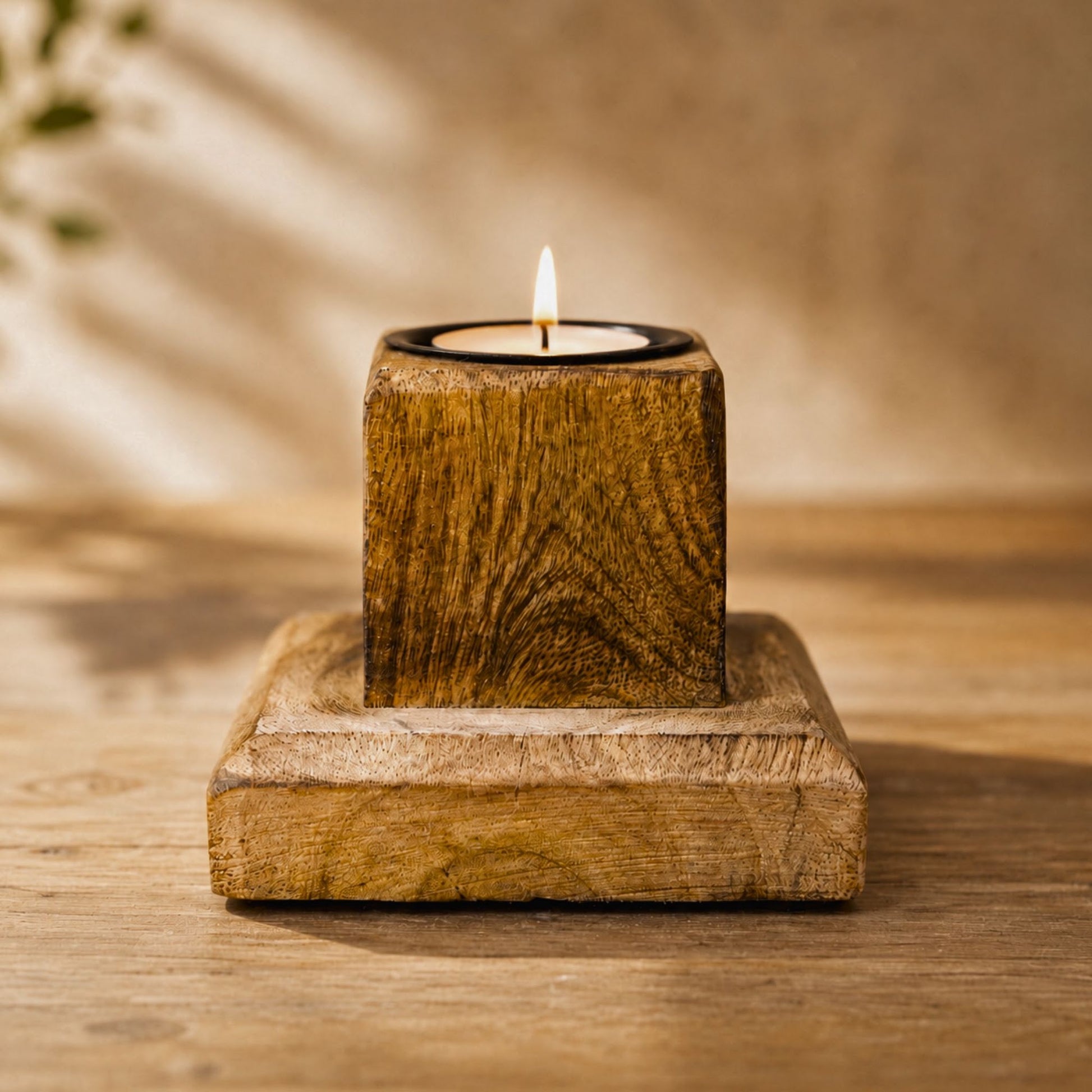 Teelichthalter aus Mangoholz mit brennendem Teelicht auf Holztisch