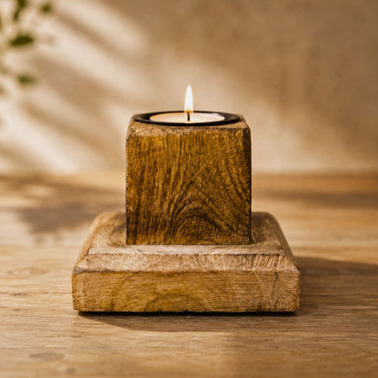 Teelichthalter aus Mangoholz mit brennendem Teelicht auf Holztisch