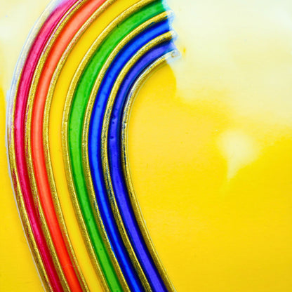 Nahaufnahme Wachsdekor Regenbogen in leuchtenden Farben mit goldener Kontur zum Kerzen verzieren