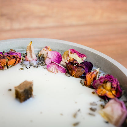 Detailaufnahme des Blütenkranzes aus Rosen und Lavendel mit Holzdocht im Wachsfresser